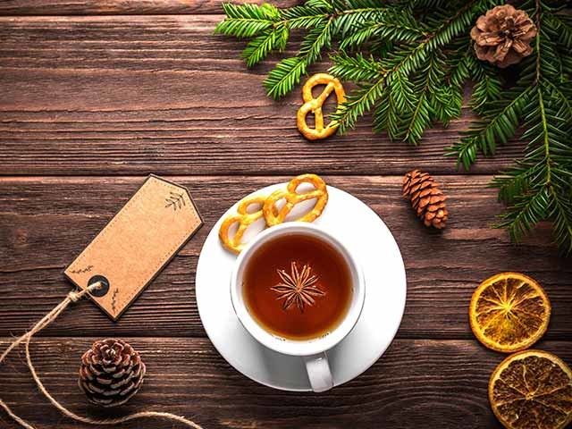 Cup of tea with dried oranges, pinecones and pine branches